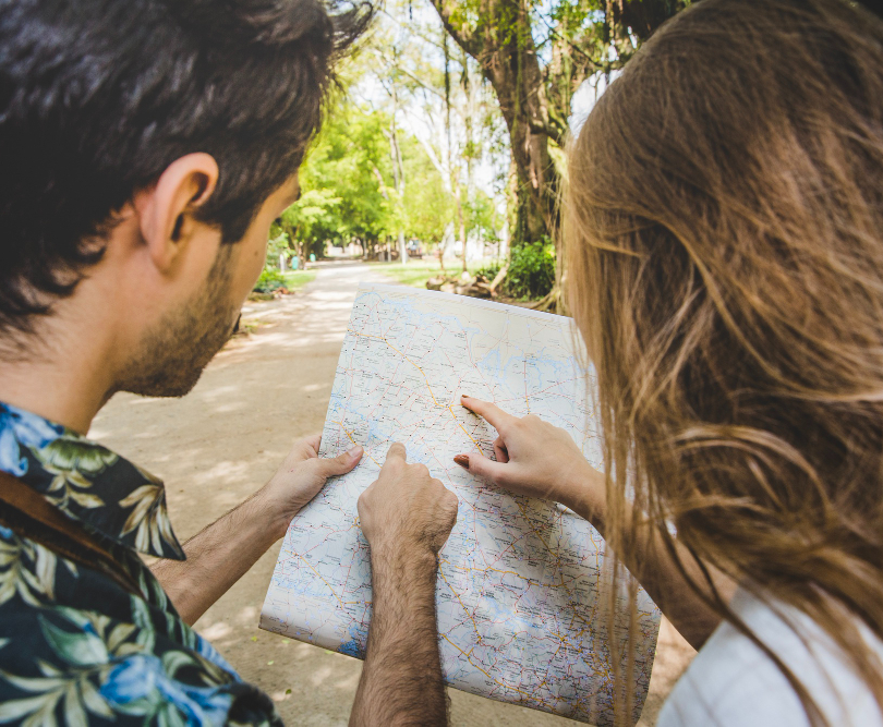 un homme et une femme en train de chercher leur route sur une carte routière