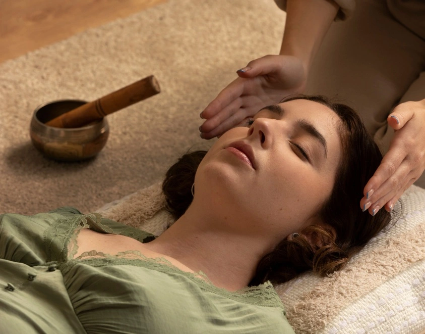 Personne qui à ses mains de chaque coté de la tête d'un femme endormie allongée au sol