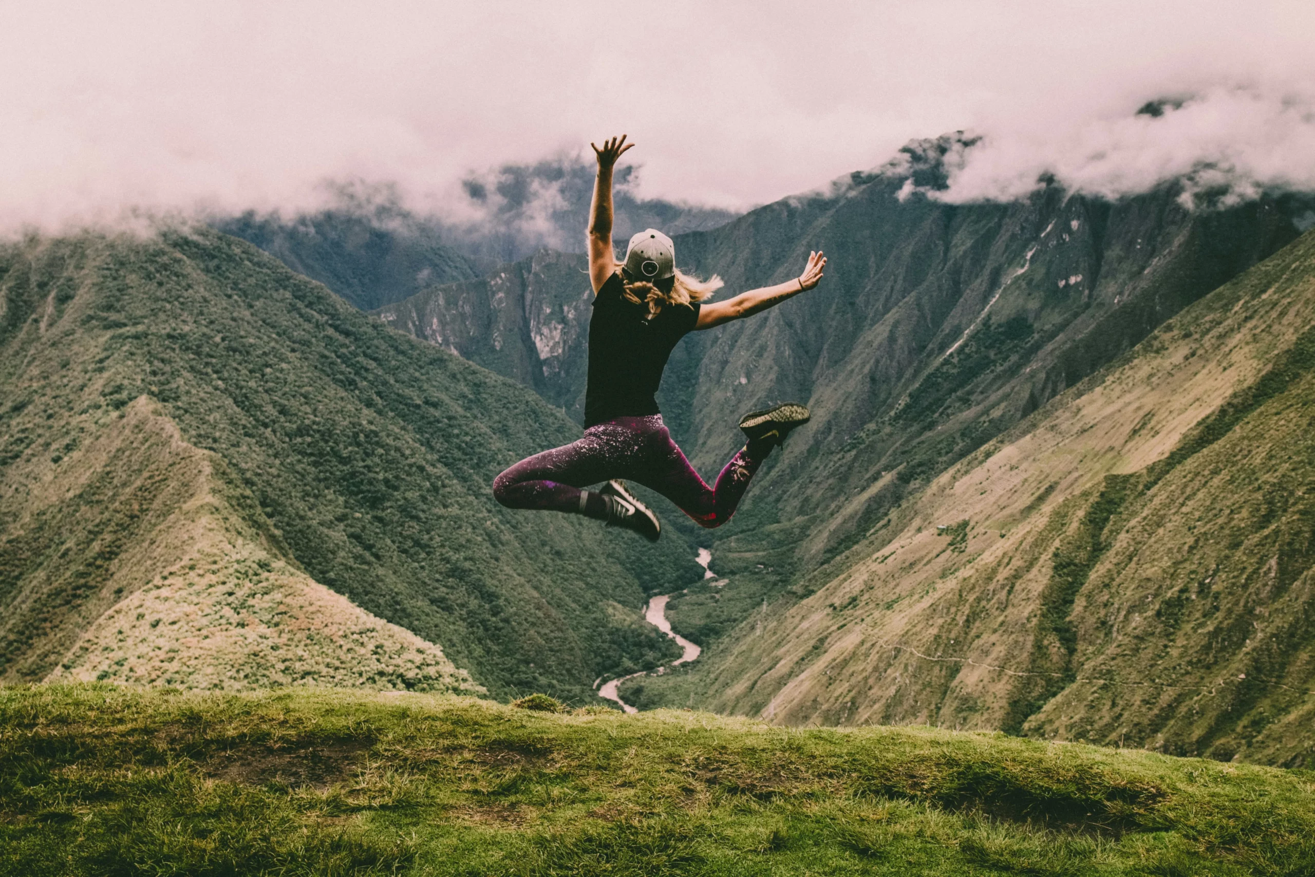 Liberté femme sautant dans les airs avec paysage montagneux en fond-Célina Morel Kinésiologue Magnétiseuse