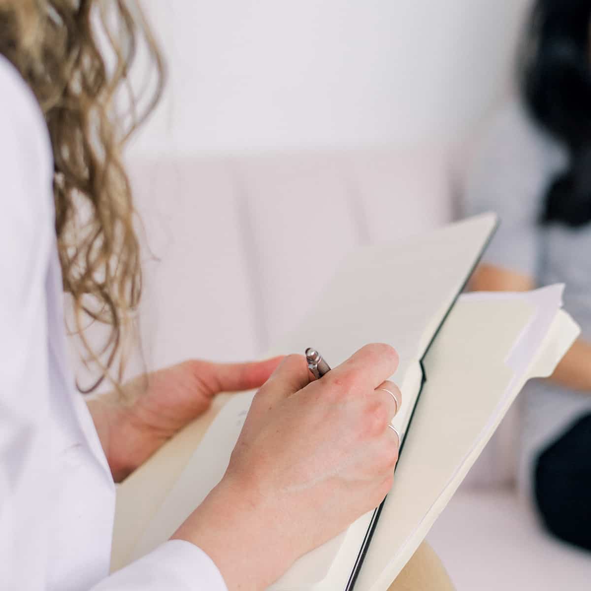 femme écrivant sur un bloc-notes